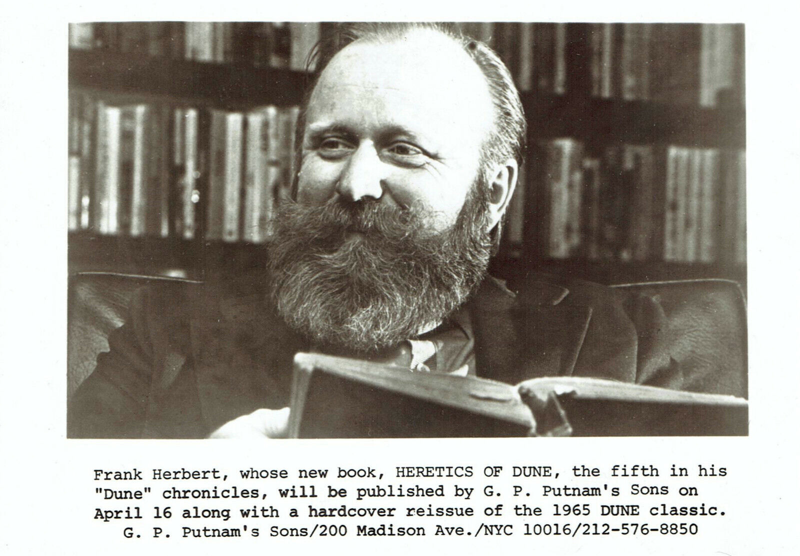 Frank Herbert reading in front of bookshelves, 1984