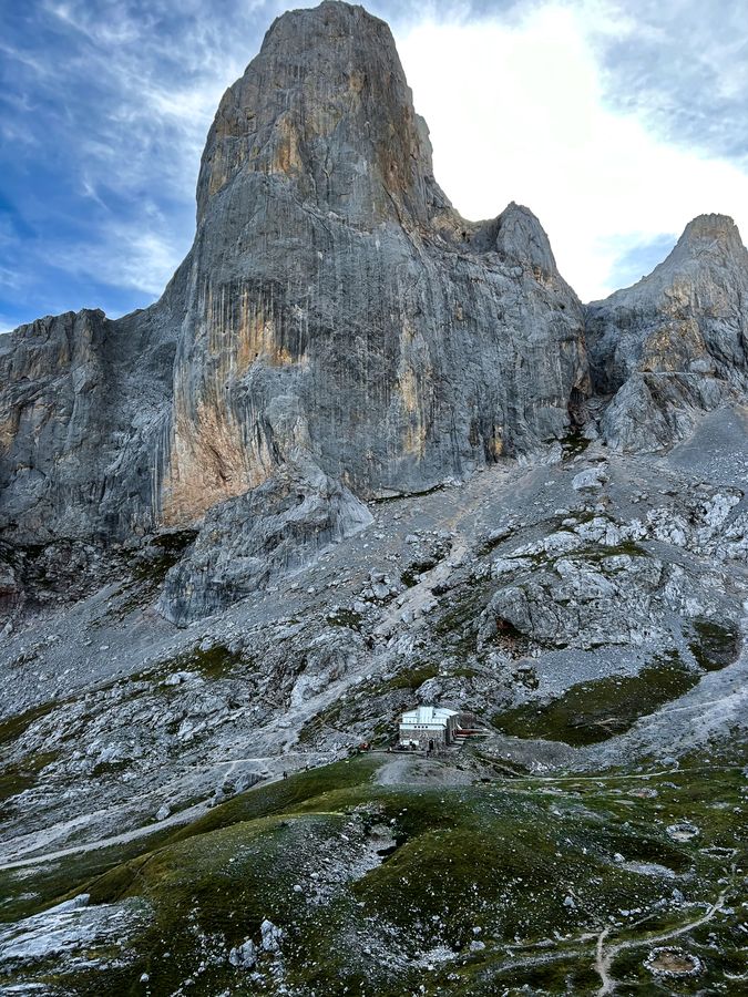 A tall limestone peak rising above a rocky mountain slope