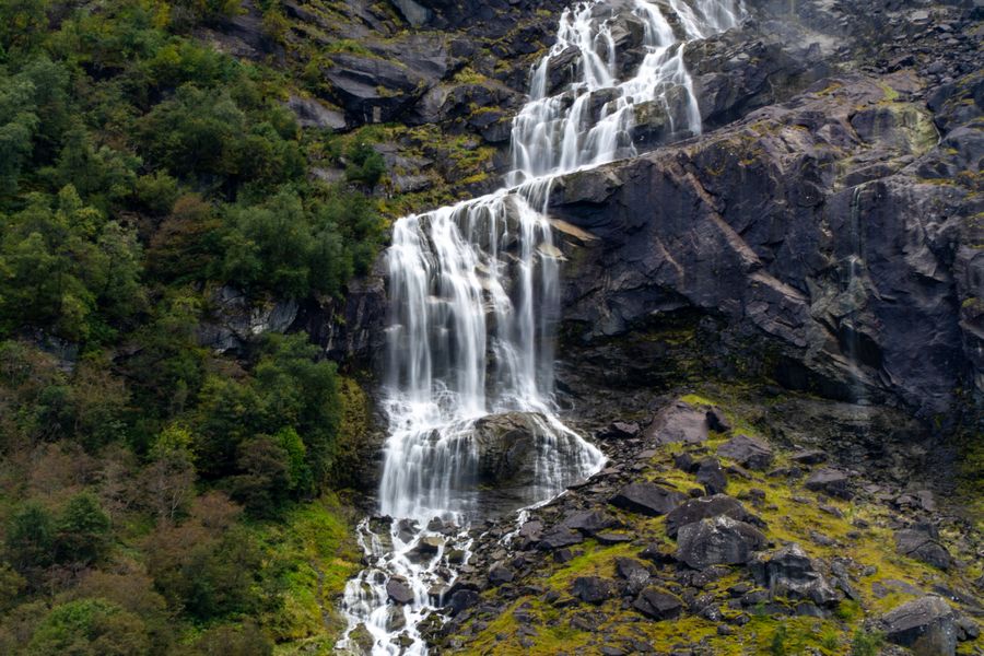 A waterfall tumbling down dark, mossy rock