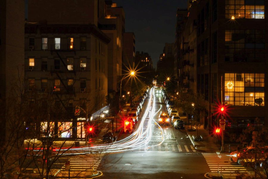 Car light trails on a long city street at night