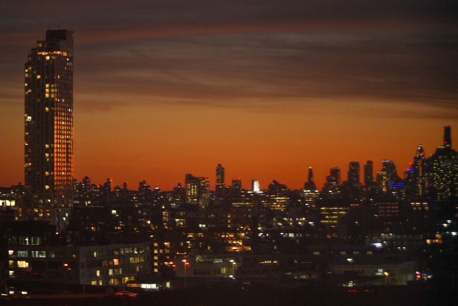 An orange sky after sunset over a city skyline