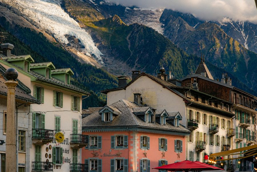 Pastel houses in a mountain town below a glacier