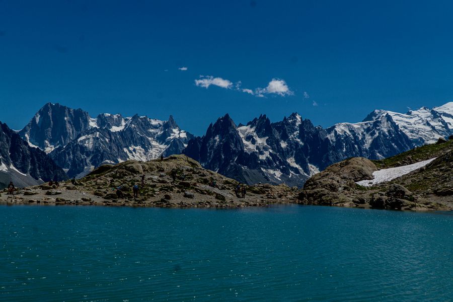 A turquoise mountain lake beneath jagged snowy peaks