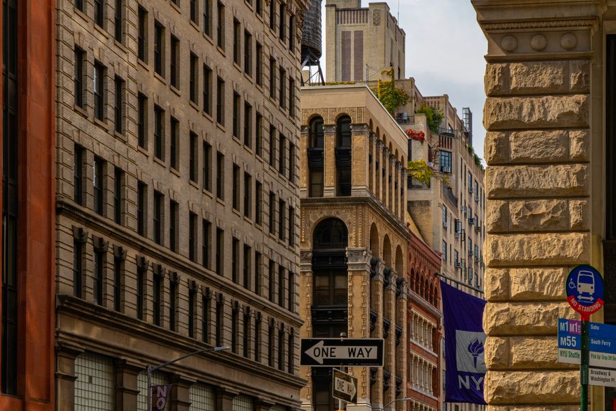 A narrow street of old office buildings beside a carved stone corner