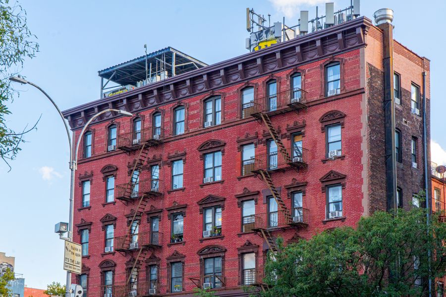 A red brick building with black fire escapes