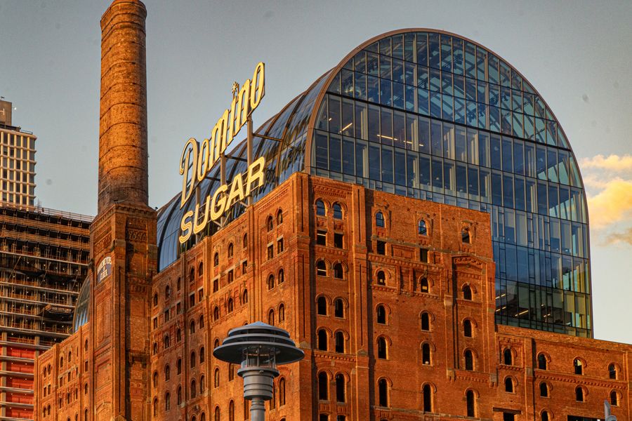 A brick sugar refinery with a glass dome and a large sign