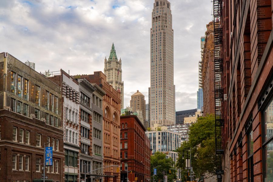 A street of old brick buildings leading to a tall Gothic tower